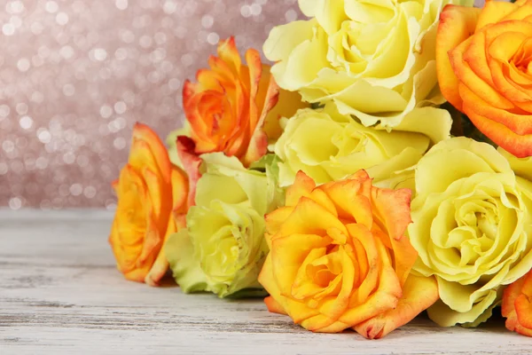 Beautiful bouquet of roses on table on brown background — Stock Photo, Image