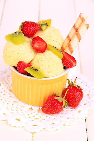 Delicioso helado con frutas y bayas en un tazón sobre una mesa de madera —  Fotos de Stock