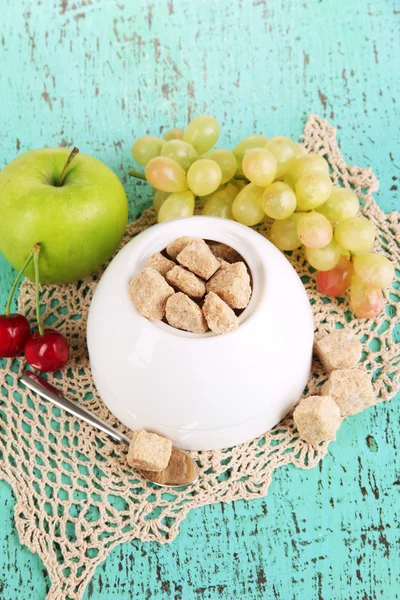 Unrefined sugar in white sugar bowl on wooden background — Stock Photo, Image