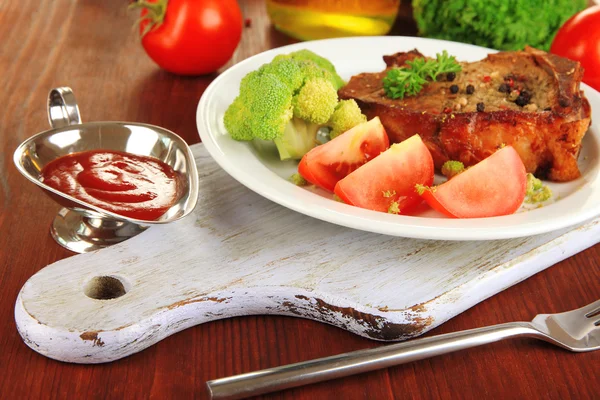 Piece of fried meat on plate on wooden table close-up — Stock Photo, Image