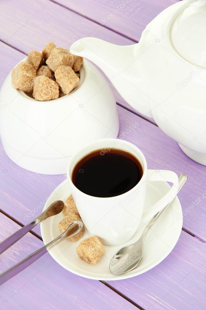 Cup of coffee, teapot and sugar-bowl on color wooden background