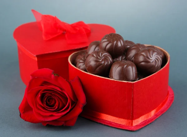 Chocolade snoepjes in de doos van de gift, op grijze achtergrond — Stockfoto