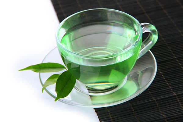Şeffaf bardak yeşil çay bambu mat, üzerinde beyaz izole — Stok fotoğraf