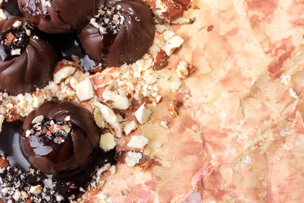 Шоколадні цукерки з горіхами на кольоровому фоні — стокове фото