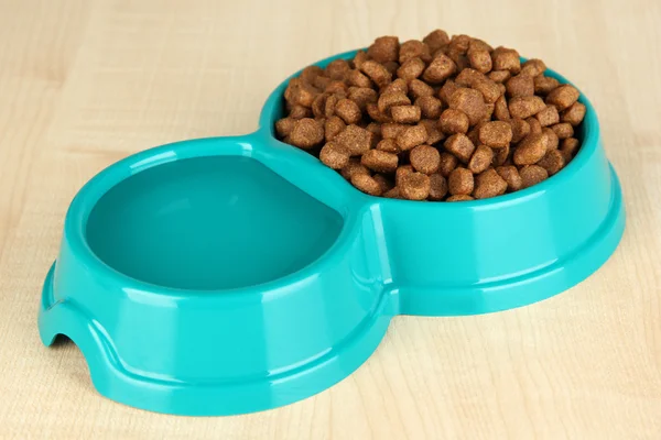 Dry dog food in bowl on wooden background — Stock Photo, Image