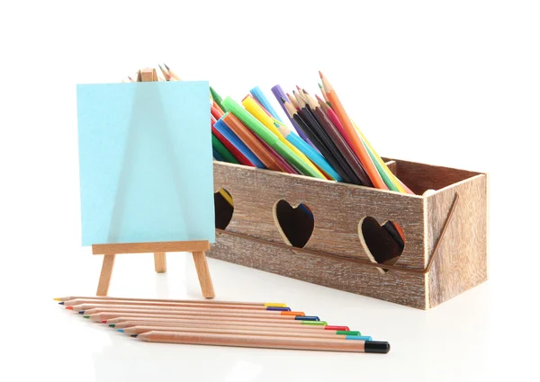 Різні олівці в дерев'яній обрешітці і мольберті, ізольовані на білому — стокове фото