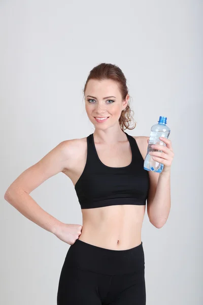 Beautiful young woman with bottle of water — Stock Photo, Image