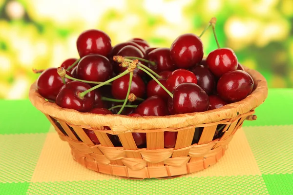 Cerise baies dans le panier en osier sur la table sur fond lumineux — Photo