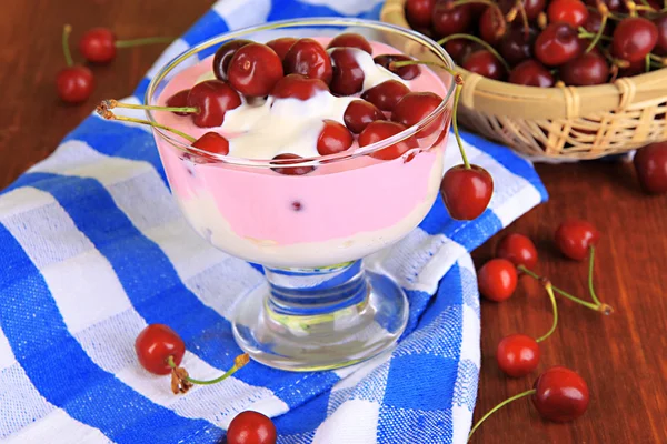 Läcker körsbär dessert i glasvas på träbord närbild — Stockfoto