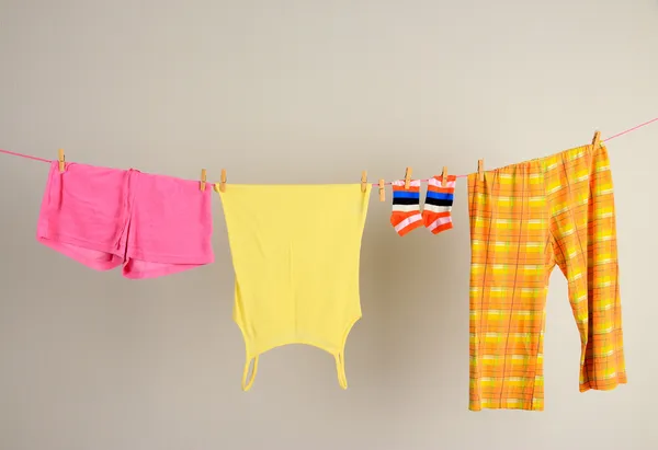 Wäscheleine mit Kleidung auf Wandhintergrund — Stockfoto