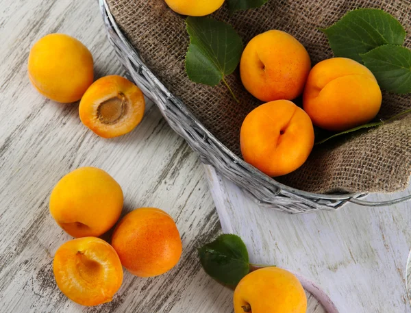 Apricots in basket on wooden table — Stock Photo, Image