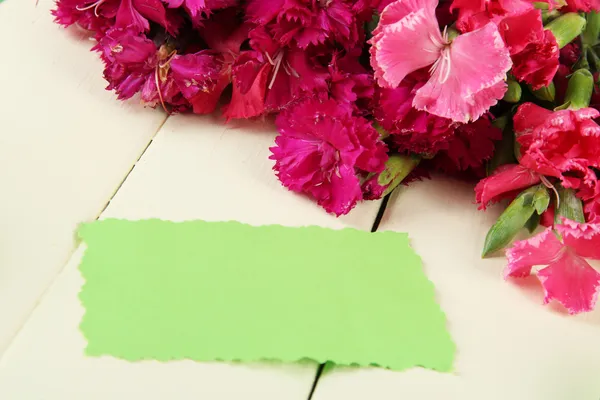 木製の背景の色のカーネーションの花束 — ストック写真