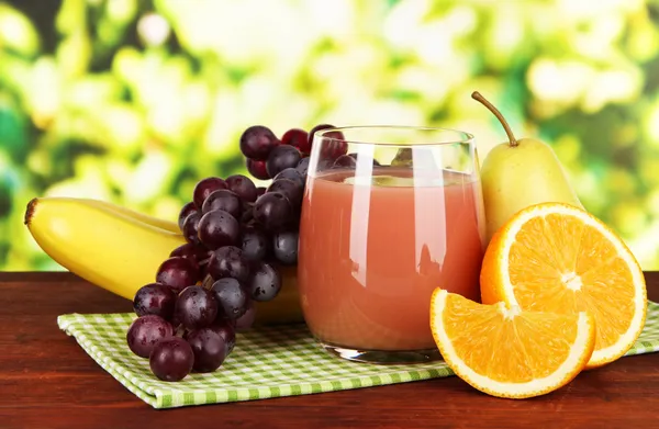 Glass of fresh juice on table on bright background — Stock Photo, Image