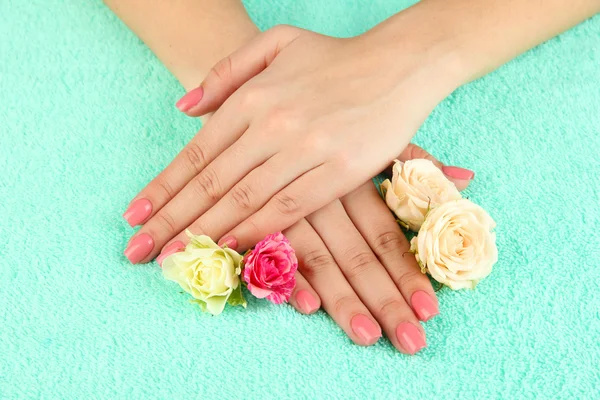 女人手中粉红色修指甲和鲜花的色彩背景 — 图库照片