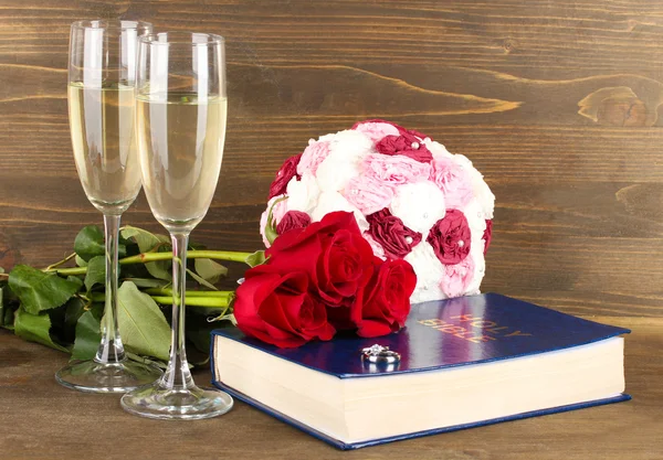 장미와 샴페인 나무 배경에 안경 성경에 결혼 반지 — 스톡 사진