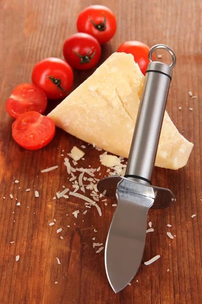 Piece of Parmesan cheese with knife on wooden table close-up — Stock Photo, Image