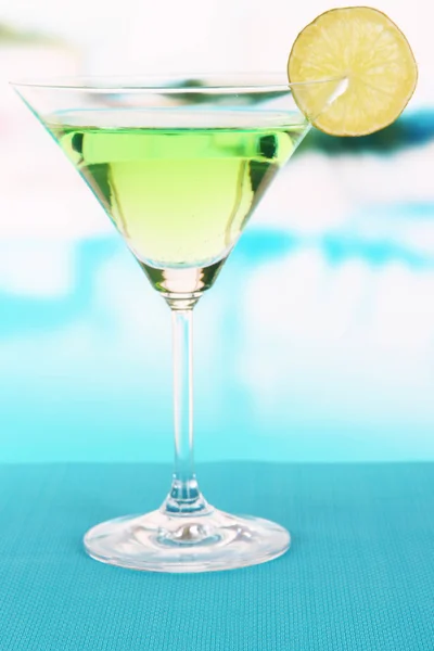 Grüner Cocktail mit Limette auf Tisch vor hellem Hintergrund — Stockfoto