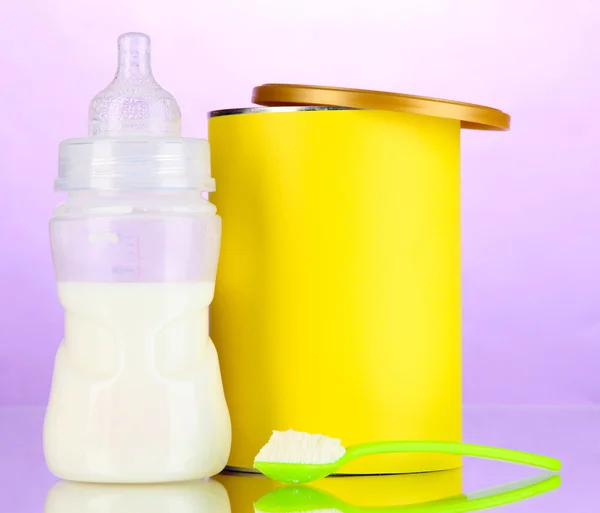 Bottle with milk and food for babies on purple background — Stock Photo, Image