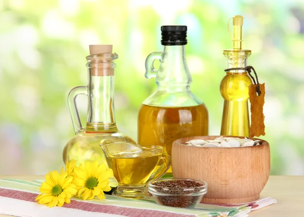 Nützliches Leinöl und Kürbiskernöl auf Holztisch vor natürlichem Hintergrund — Stockfoto