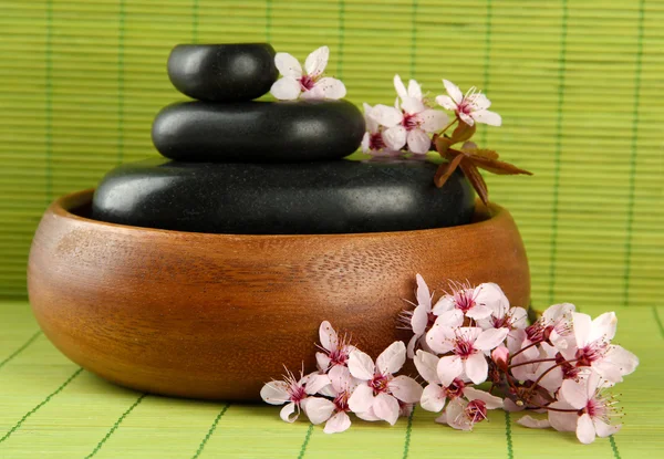 Spa stones and flowers on bamboo background — Stock Photo, Image