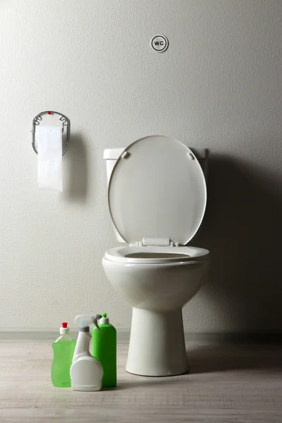 White toilet bowl and cleaning supplies in a bathroom — Stock Photo, Image