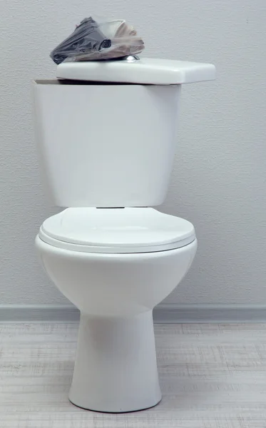 Argent et arme sur le réservoir de toilettes dans une salle de bain — Photo