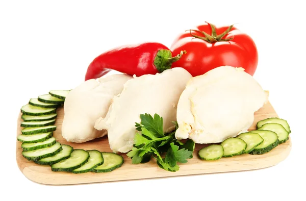 Boiled chicken breast on wooden cutting board with vegetables isolated on white — Stock Photo, Image