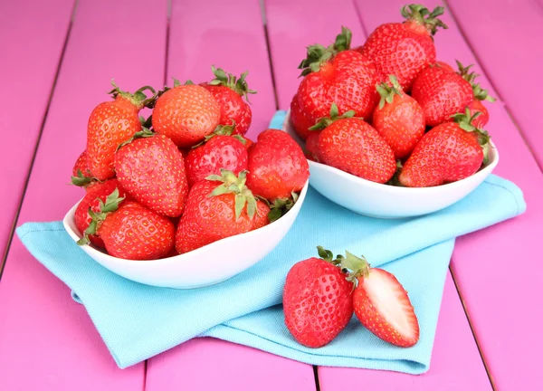 Fresh strawberry in bowl on pink wooden background — Stock Photo, Image