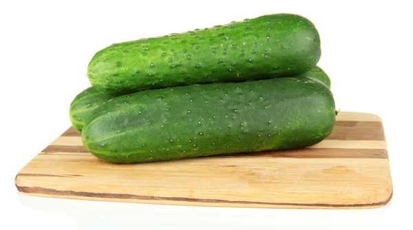 Tasty green cucumbers on wooden cutting board, isolated on white — Stock Photo, Image