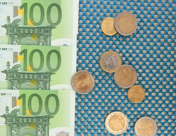 Eurobankovky a euro centů na modrém pozadí — Stock fotografie