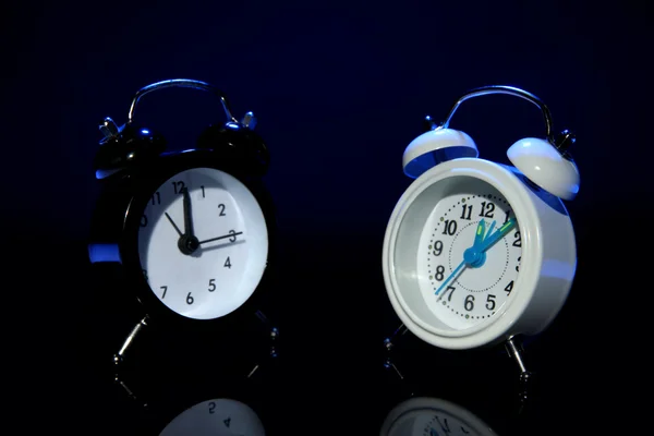 Dos relojes de alarma de estilo antiguo sobre fondo de color oscuro —  Fotos de Stock
