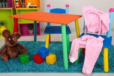 küçük ve renkli masa ve sandalyeler ile bebek giysileri