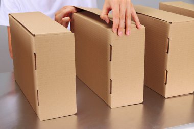 gri arka plan üzerinde Konveyör bant kutuları ile çalışan işçi