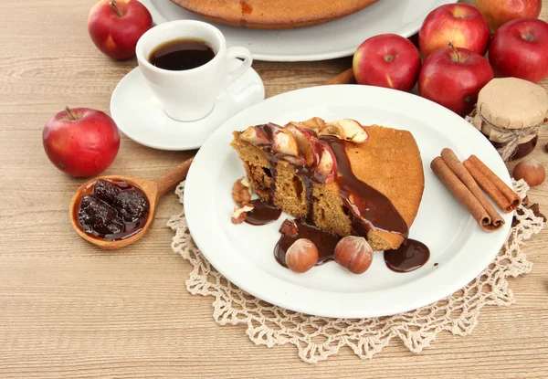 Ломтик вкусного домашнего пирога с шоколадом и яблоками и чашкой кофе, на деревянном столе — стоковое фото