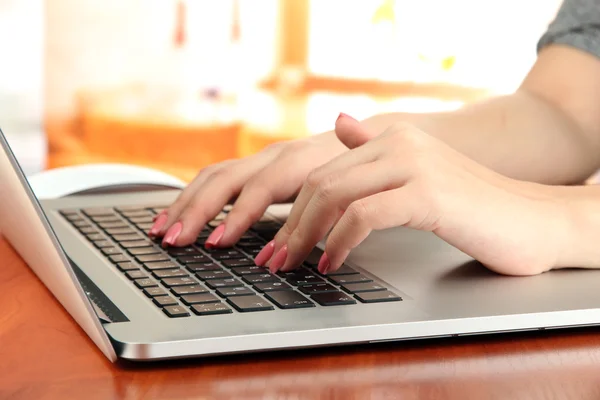 Mãos femininas escrevendo no laptop, no fundo brilhante — Fotografia de Stock