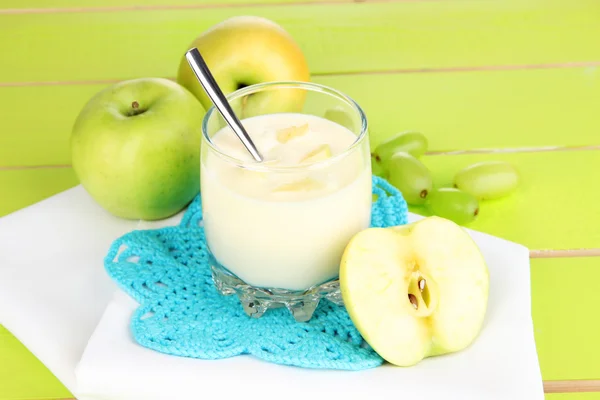 Delicious yogurt in glass with fruit on blue tablecloth — Stock Photo, Image