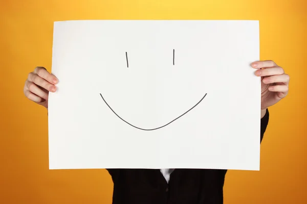 Frau hält Papier mit Lächeln, auf farbigem Hintergrund — Stockfoto
