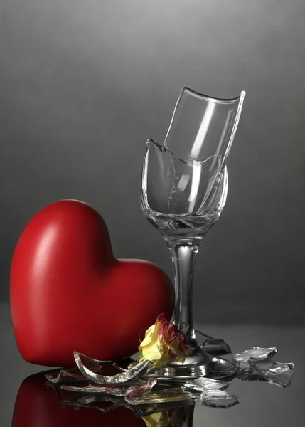 Σπασμένα wineglass και καρδιά σε γκρι φόντο — Φωτογραφία Αρχείου