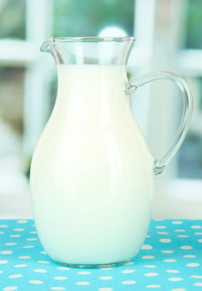 Pitcher of milk on table in room — Stock Photo, Image