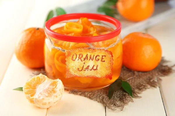 Orangenmarmelade mit Schale und Mandarinen, auf weißem Holztisch — Stockfoto