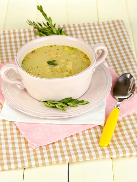 Nourishing soup in pink pan on wooden table close-up — Stock Photo, Image