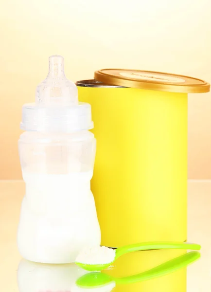 Bottle with milk and food for babies on beige background — Stock Photo, Image