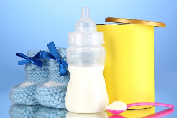 Bottle with milk and food for babies on blue background — Stock Photo, Image