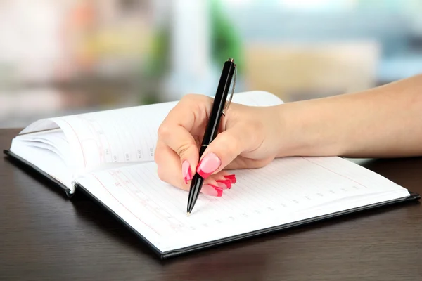 Assinatura de mão em notebook, em fundo brilhante — Fotografia de Stock