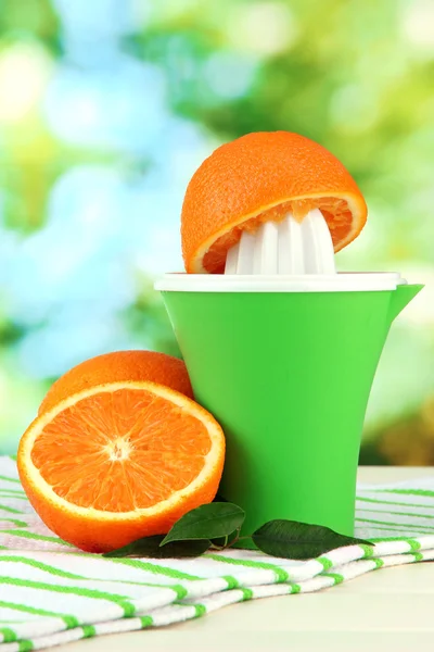 Citrus press and ripe oranges on white wooden table — Stock Photo, Image