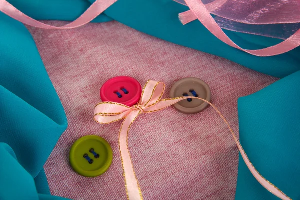 Three buttons on gray and blue cloth — Stock Photo, Image