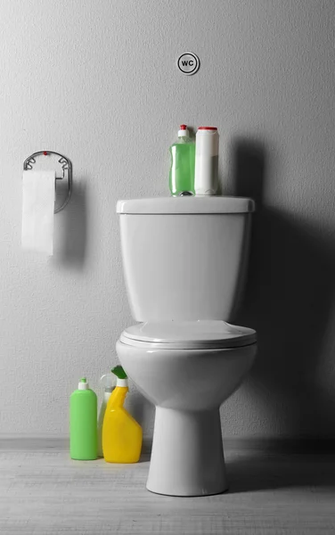 White toilet bowl and cleaning supplies in a bathroom — Stock Photo, Image