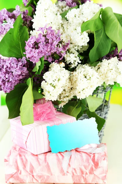 Beautiful lilac flowers, on wooden table on bright background — Stock Photo, Image