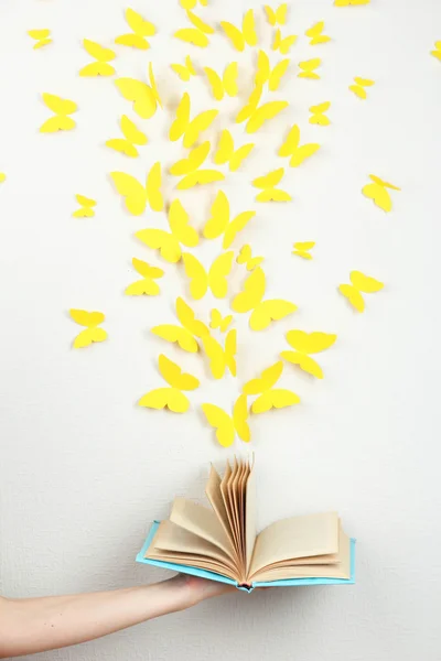 Paper yellow butterflies fly out of book