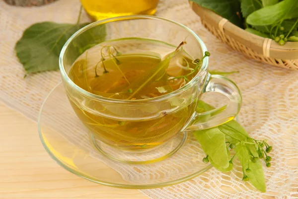 Glass cup of tea with linden on wooden table close-up — Stock Photo, Image